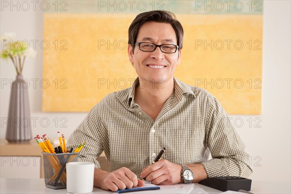 Portrait of man doing paperwork. Photo : Rob Lewine