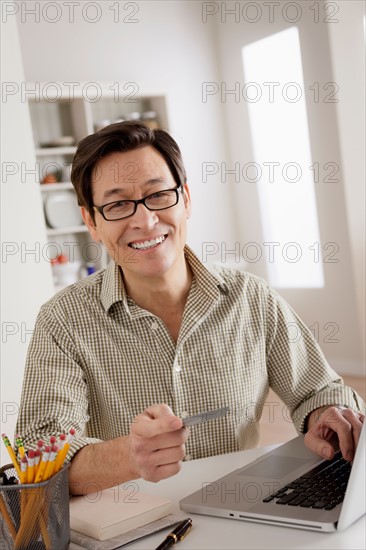 Portrait of man shopping online from home. Photo : Rob Lewine