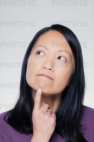 Studio portrait of mature woman looking up. Photo : Rob Lewine