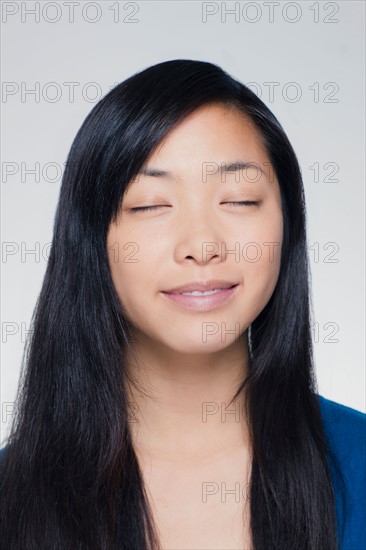 Studio portrait of young woman daydreaming. Photo : Rob Lewine