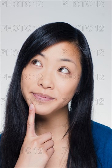 Studio portrait of young woman looking up. Photo : Rob Lewine