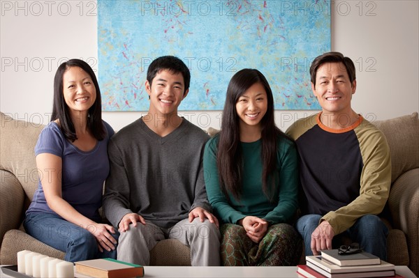 Portrait of family sitting on couch. Photo : Rob Lewine