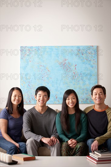 Portrait of family sitting on couch. Photo : Rob Lewine