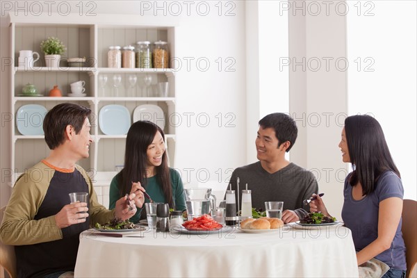 Happy family having meal together. Photo : Rob Lewine