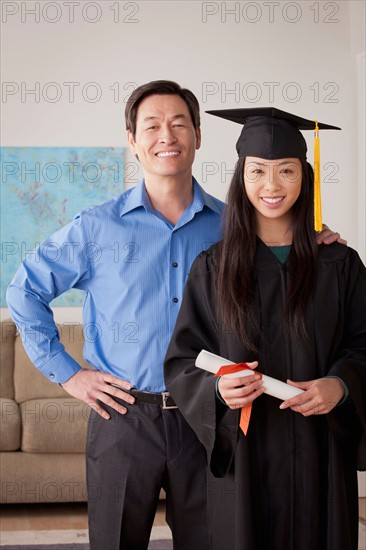 Portrait of young woman in graduation gown with mother and brother. Photo : Rob Lewine