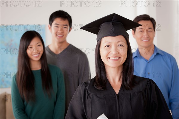 Portrait of mature woman in graduation gown with family. Photo : Rob Lewine