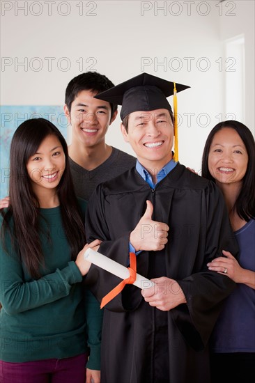 Portrait of mature man in graduation gown with family. Photo : Rob Lewine