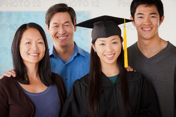 Portrait of mature woman in graduation gown with family. Photo : Rob Lewine