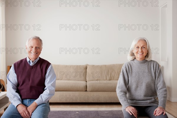 Portrait of senior couple sitting on sofa. Photo : Rob Lewine