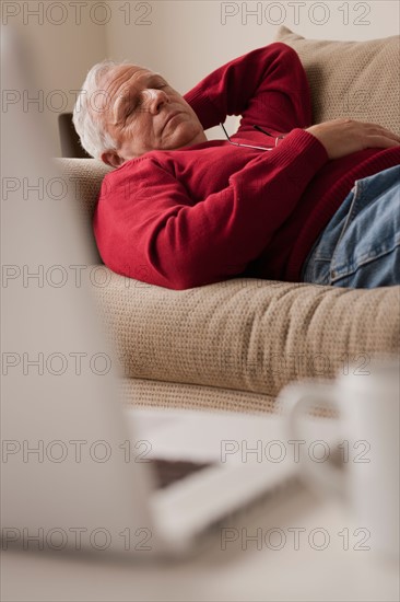 Senior man sleeping on sofa. Photo : Rob Lewine
