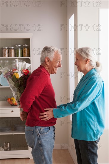 Senior man giving flower to woman. Photo : Rob Lewine