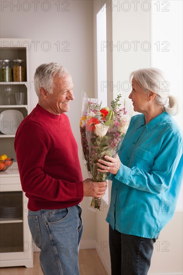 Senior man giving flower to woman. Photo : Rob Lewine