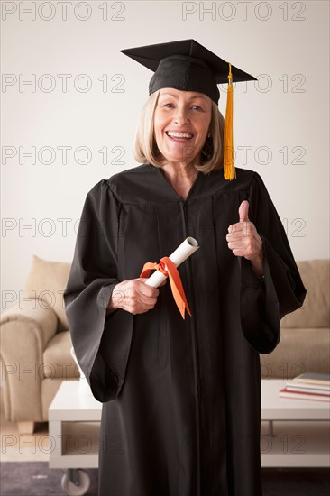 Senior woman wearing graduation gown. Photo : Rob Lewine