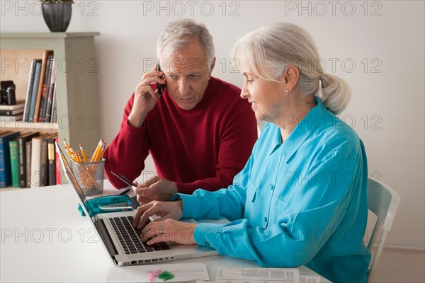 Senior couple using laptop together. Photo : Rob Lewine