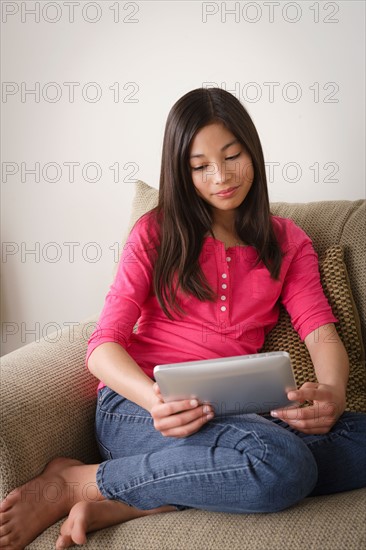 Portrait of smiling girl (12-13) using digital tablet. Photo : Rob Lewine