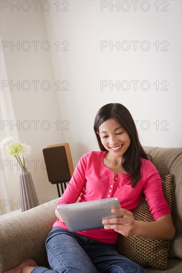 Portrait of smiling girl (12-13) using digital tablet. Photo : Rob Lewine