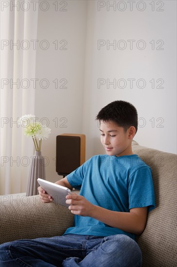 Smiling boy (10-11) using digital tablet. Photo : Rob Lewine