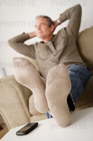 Mature man resting on sofa. Photo : Rob Lewine