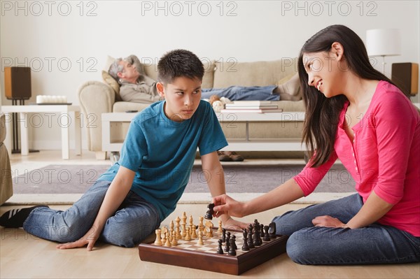 Siblings playing chess game. Photo : Rob Lewine