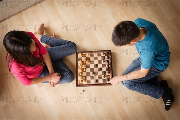 Siblings playing chess game. Photo : Rob Lewine