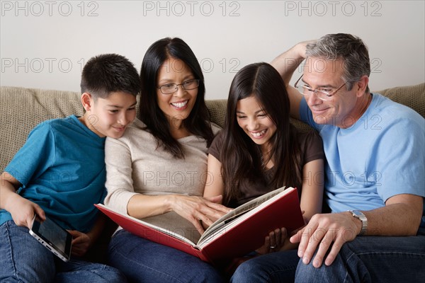 Family watching photo album together. Photo : Rob Lewine