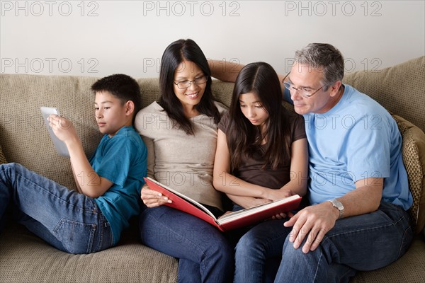 Family watching photo album together. Photo : Rob Lewine