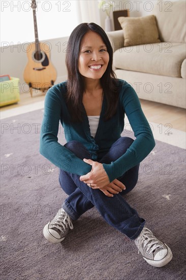 Smiling woman sitting on floor. Photo : Rob Lewine