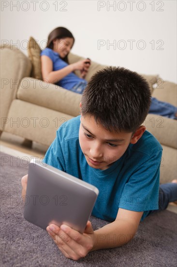 Boy using iPad lying on floor. Photo : Rob Lewine