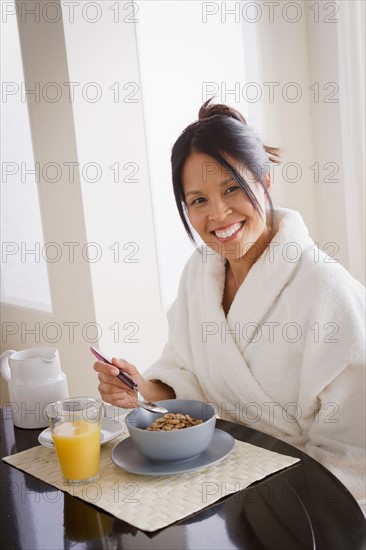Woman having cereal for breakfast. Photo : Rob Lewine