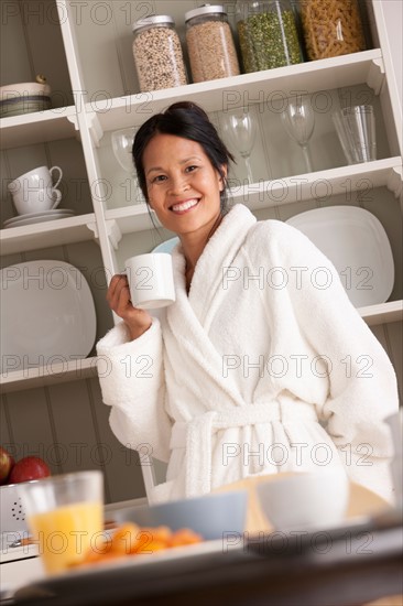 Woman in bathrobe with coffee cup. Photo : Rob Lewine