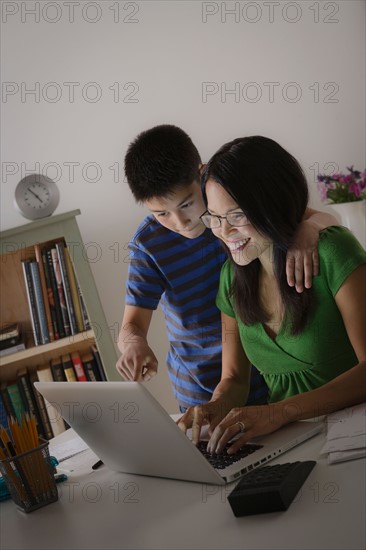 Mother with son using laptop together. Photo : Rob Lewine