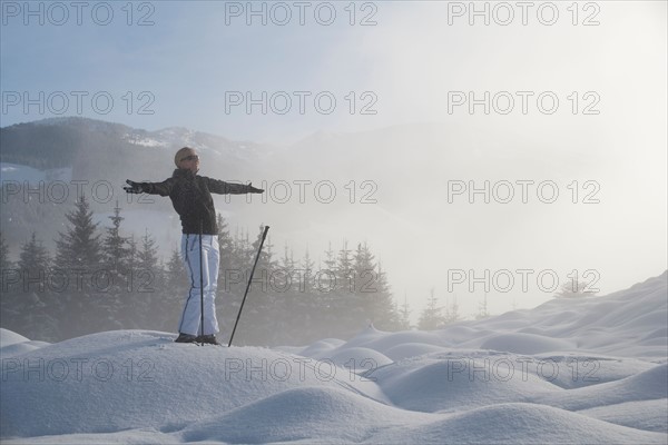 Austria, Maria Alm. Young woman hiking in winter scenery. Photo : Mark de Leeuw