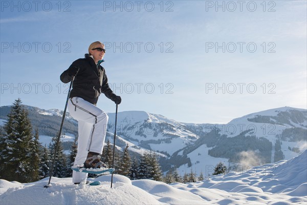 Austria, Maria Alm. Young woman hiking in winter scenery. Photo : Mark de Leeuw