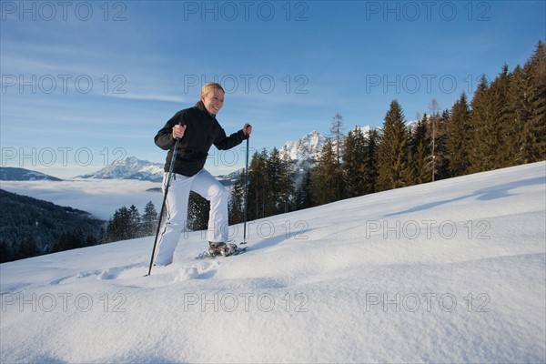 Austria, Maria Alm. Young woman hiking in winter scenery. Photo : Mark de Leeuw