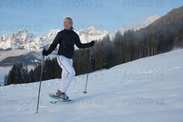 Austria, Maria Alm. Young woman hiking in winter scenery. Photo : Mark de Leeuw