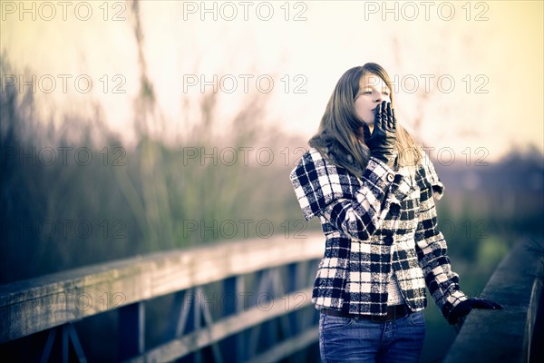 Young woman walking in winter sun. Photo : Mark de Leeuw