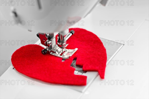 Sewing together parts of broken heart. Photo : Elena Elisseeva