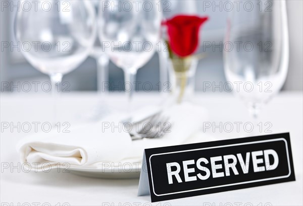 Dishes and cutlery prepared for meal in restaurant with reserved sign. Photo : Elena Elisseeva