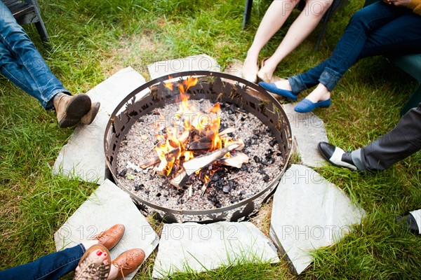 Group of friends sitting by bonfire. Photo : Jessica Peterson