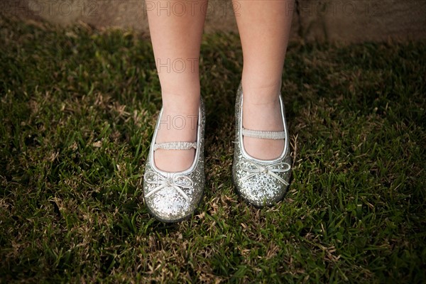 Close-up view of girl's (4-5) legs on grass. Photo : Jessica Peterson
