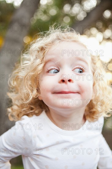 Outdoor portrait of cute blonde girl (4-5) pulling funny faces. Photo : Jessica Peterson