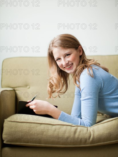 Indoor portrait of young attractive woman reclining on sofa. Photo : Jessica Peterson