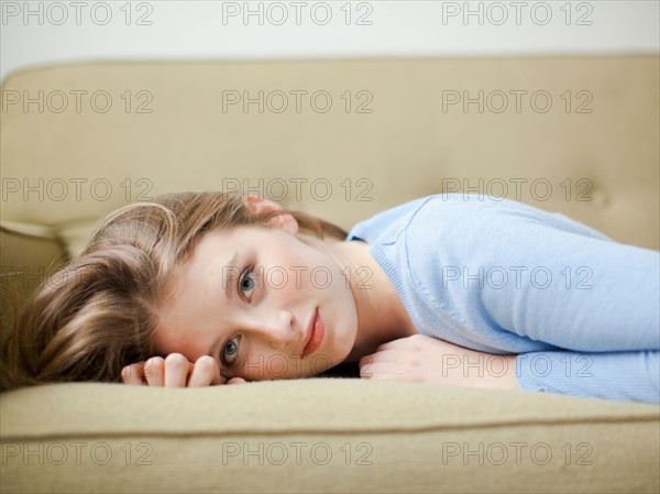 Indoor portrait of young attractive woman reclining on sofa. Photo : Jessica Peterson