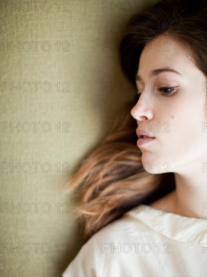 Young woman relaxing on sofa. Photo : Jessica Peterson