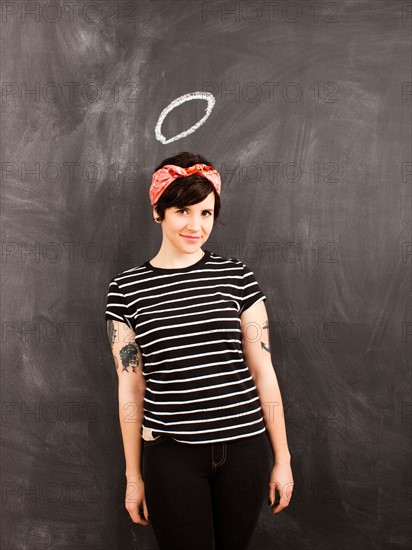 Portrait of young woman in front of blackboard. Photo : Jessica Peterson