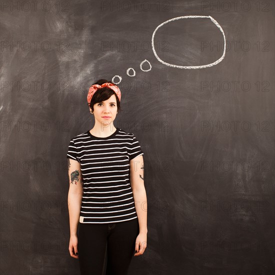 Portrait of young woman in front of blackboard. Photo : Jessica Peterson