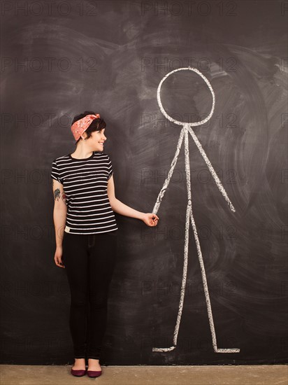 Portrait of young woman in front of blackboard. Photo : Jessica Peterson