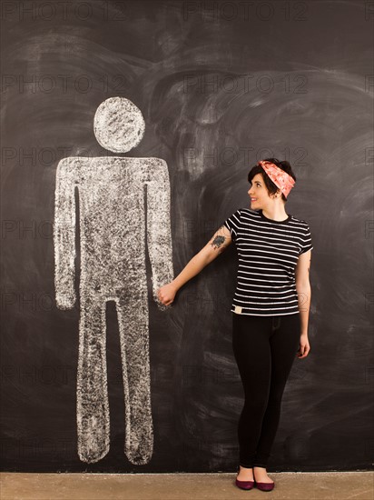 Portrait of young woman in front of blackboard. Photo : Jessica Peterson