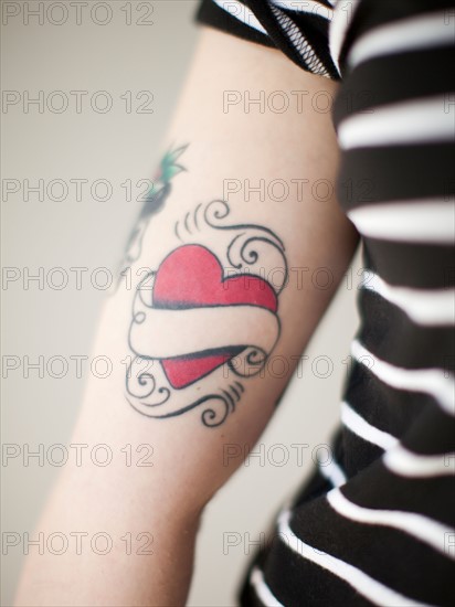 Heart shaped tattoo on woman's arm. Photo : Jessica Peterson