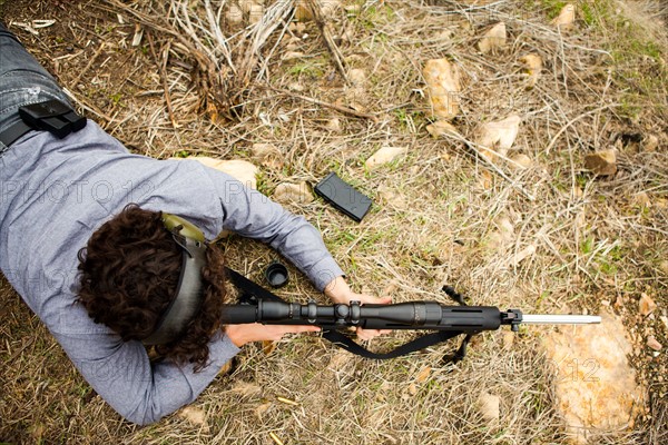 Man lying on front with weapon. Photo : Jessica Peterson